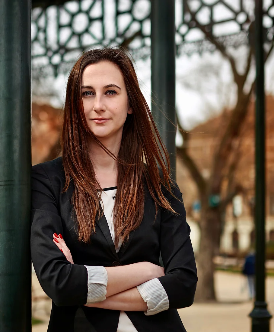 A portrait photo of Boglarka, standing in front of a blurred background